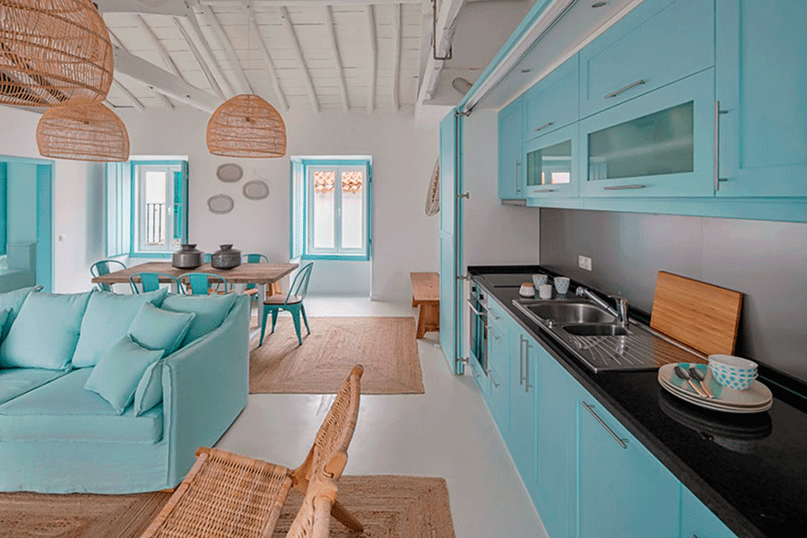 miaje cocina casa playa celeste con encimera negra lámparas de mimbre