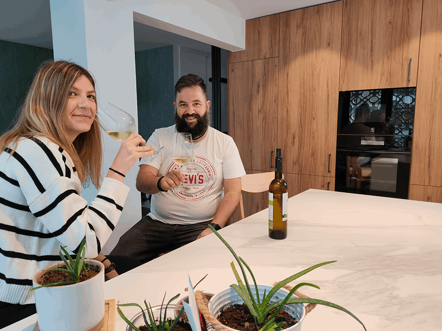 miaje pareja brinda en cocina moderna con isla