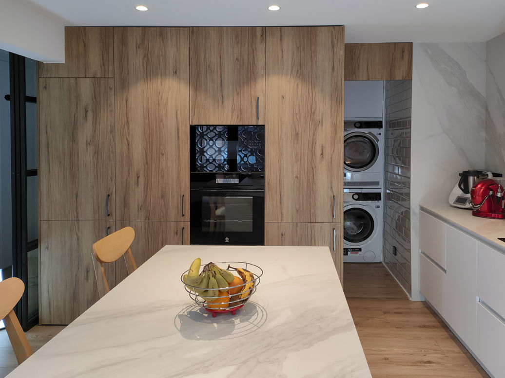 miaje cocina moderna con lavandería con isla blanca y madera con encimera mármol claro con veta gris