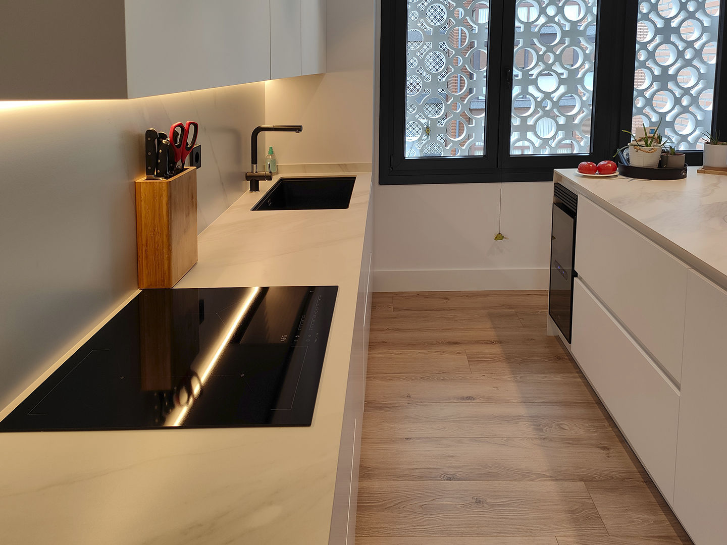 miaje cocina moderna con isla blanca y madera con encimera mármol claro con veta gris