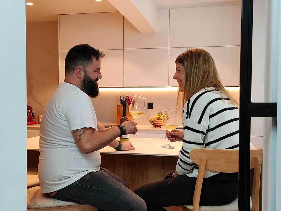 miaje pareja brindando en cocina moderna con isla