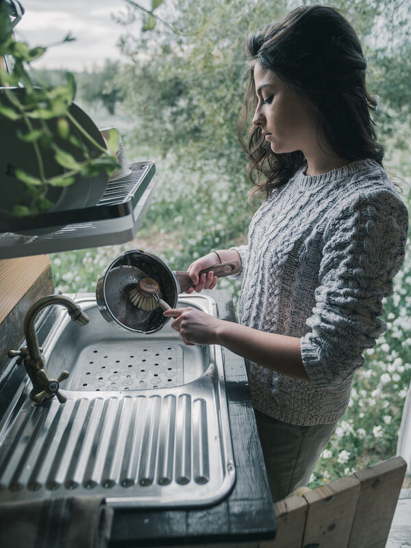 miaje chica fregando cazo con cepillo
