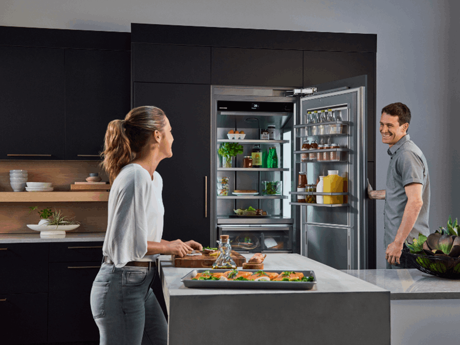 miaje pareja en cocina moderna oscura con isla nevera abierta